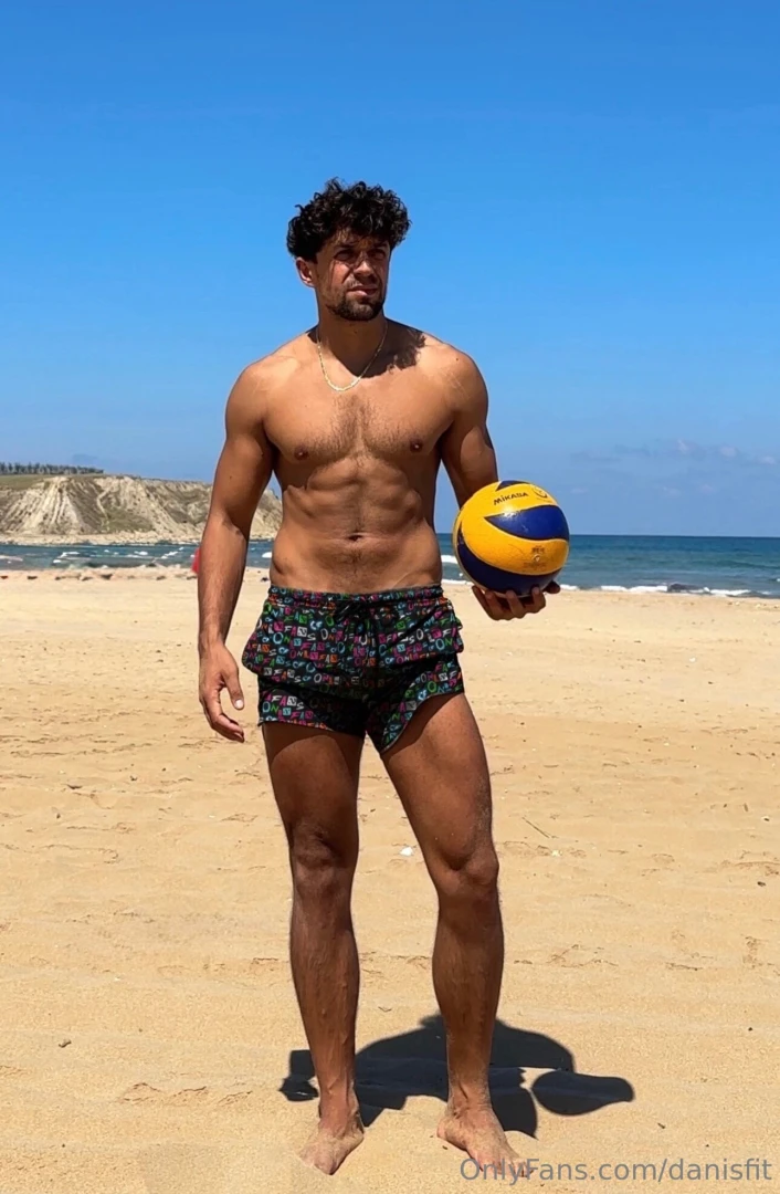 A beautiful beach nice short perfect weather and a volleyball what 