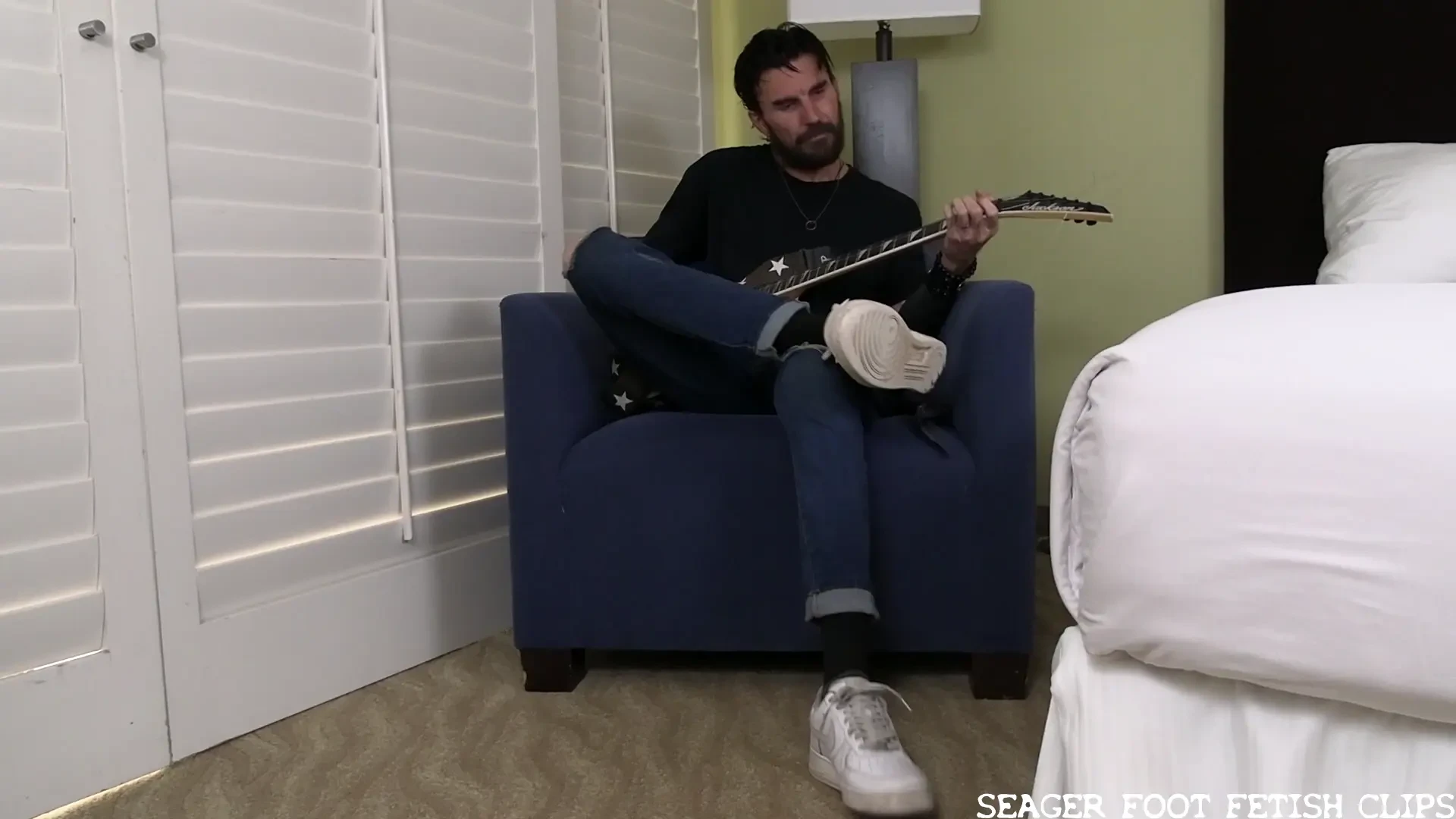Sexy rock band guitarist bennett kicks back with his instrument and 