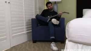 Sexy rock band guitarist bennett kicks back with his instrument and