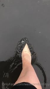 Nude patent jimmy choo stilettos in a puddle and walking in the rain