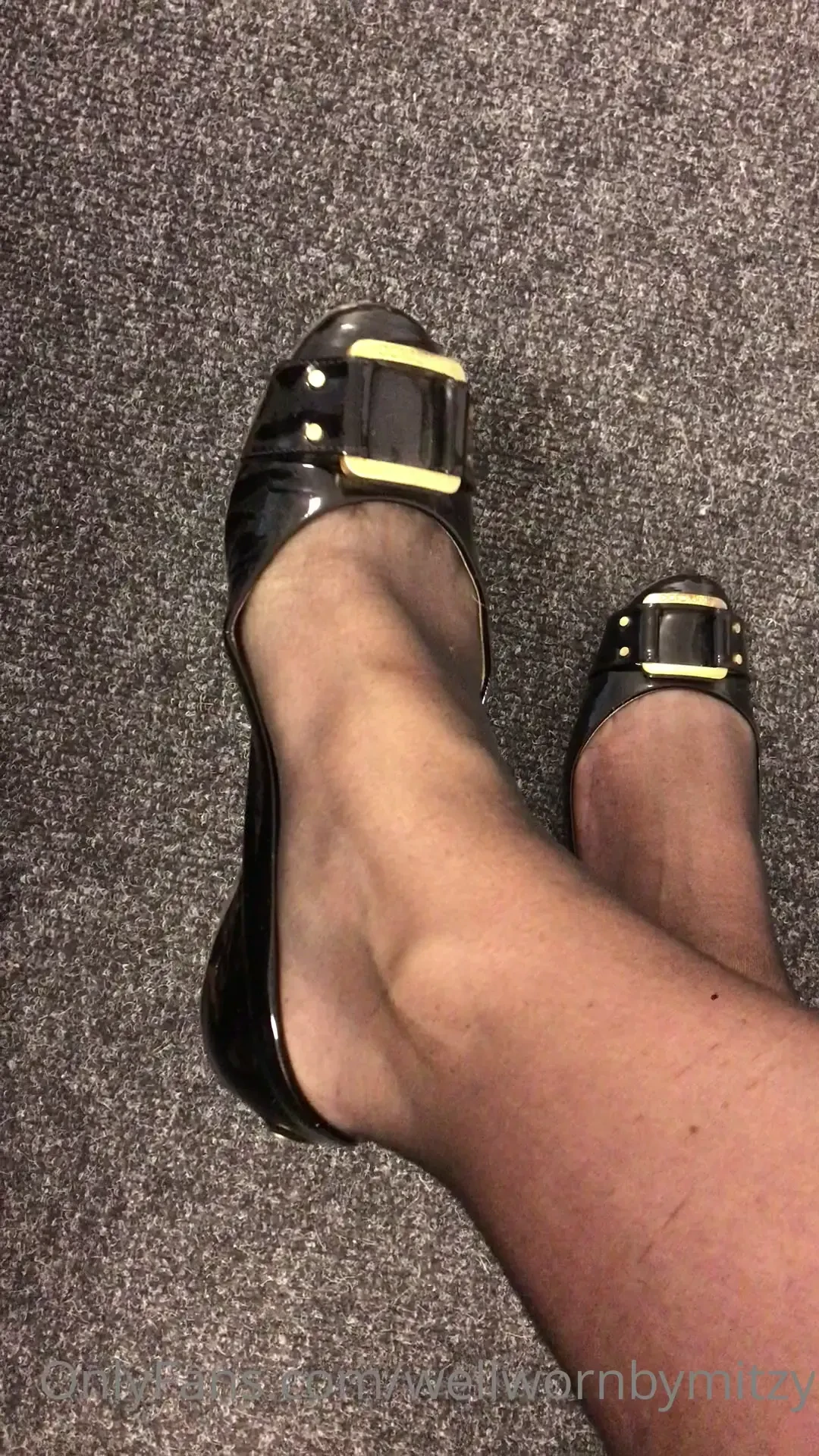 Black patent jimmy choo flats and stockings sat dangling 