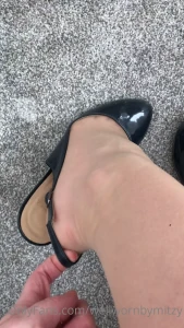 Putting on navy patent sling backs stretching the strap nude nylons