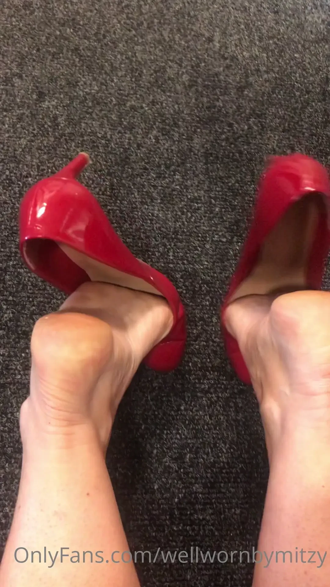 On my knees red patent pumps heel pop to show bare soles 