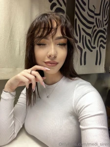 The white sweater emphasizes the tenderness and the pendant lies where