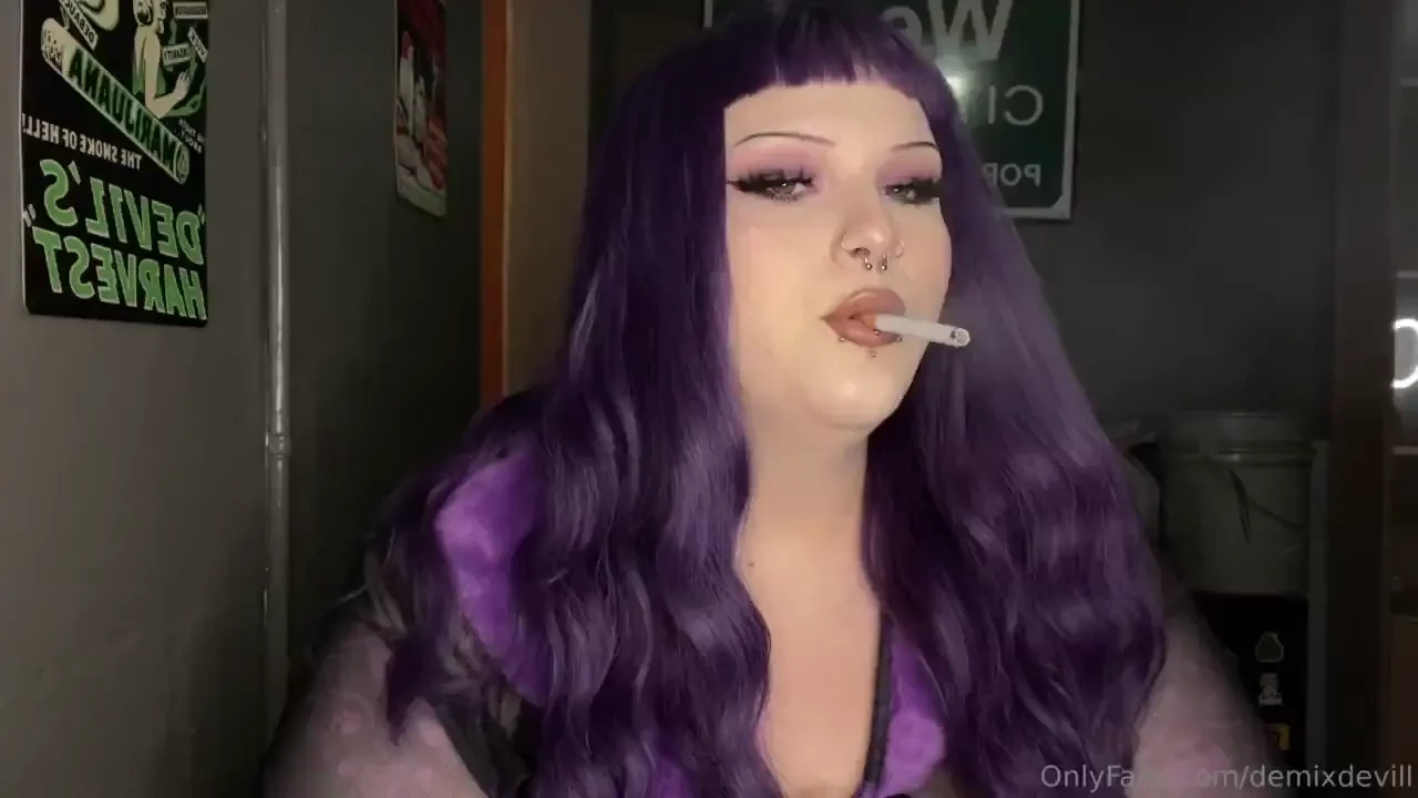 Smoking a dangling cigarette deep inhales 