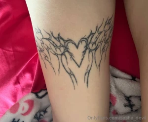 Trible with a heart on the opposite thigh this is a tattoo designed by