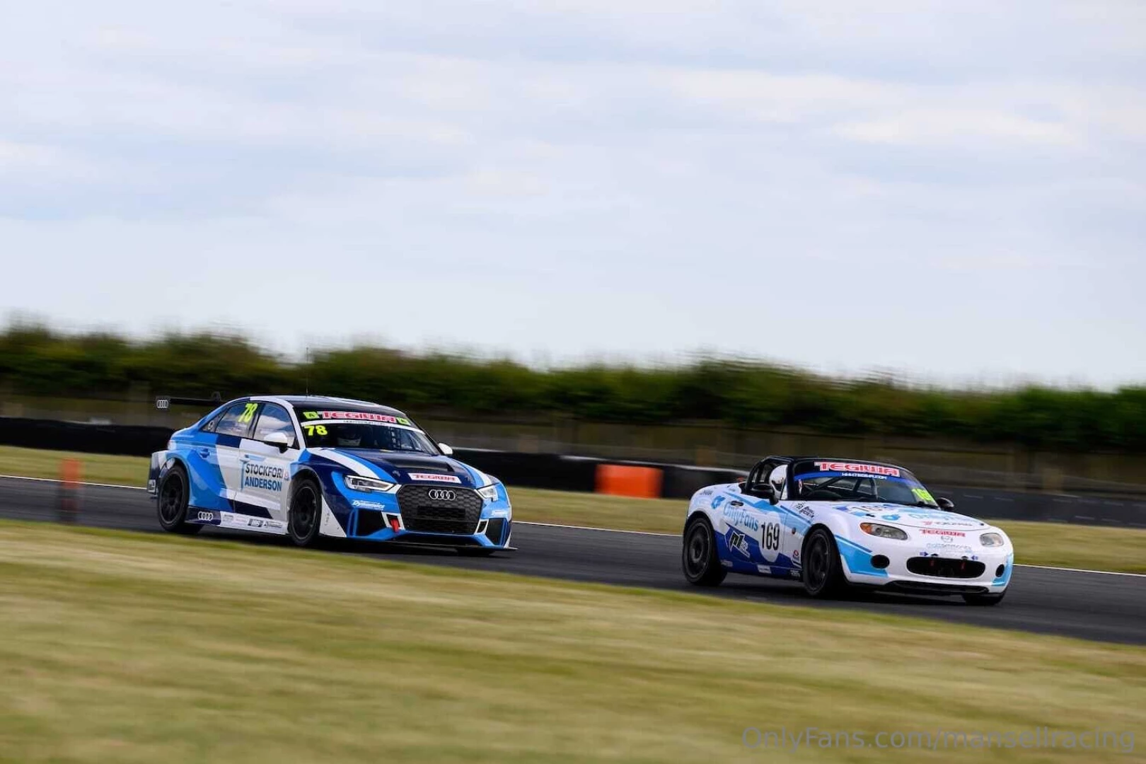 The mx5 looks tiny with a big boy class a car breathing down it s neck 