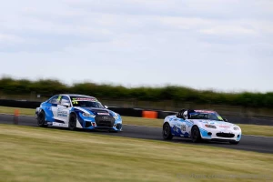 The mx5 looks tiny with a big boy class a car breathing down it s neck