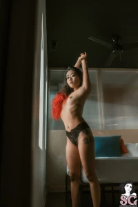 Megami sat like a slow burn legs draped eyes daring and black lace