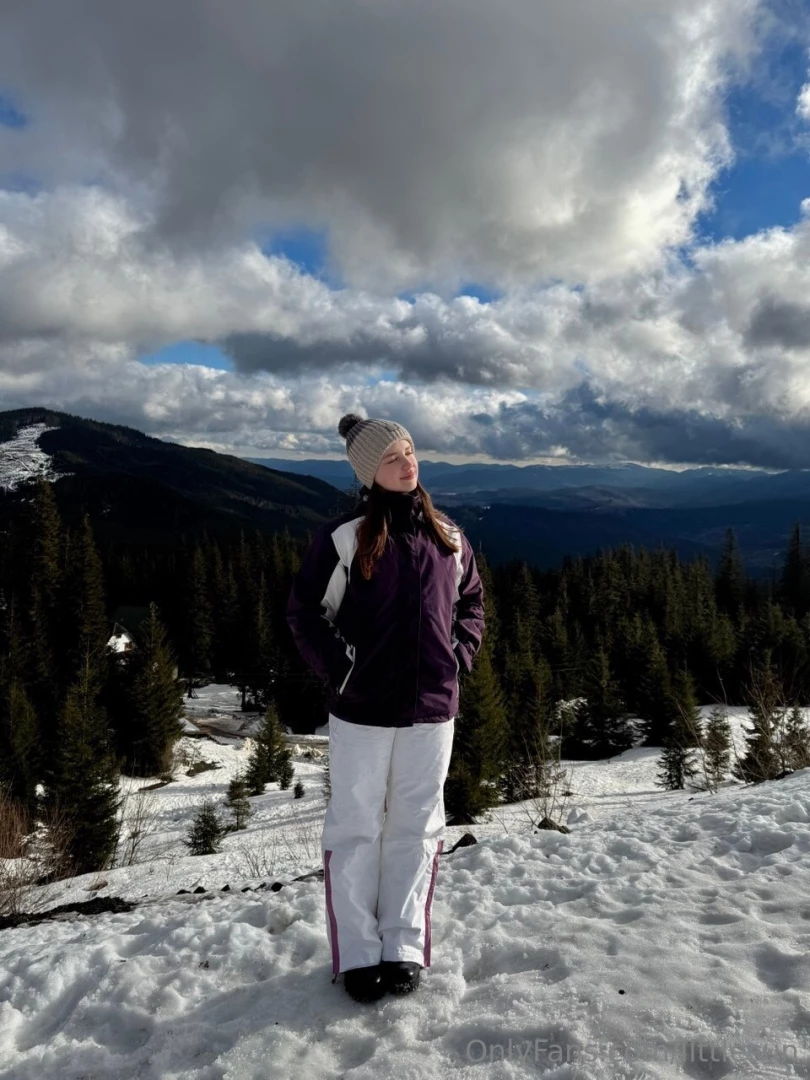 I m standing on top of a mountain surrounded by snow-covered trees and 