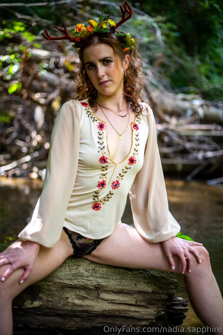 Whimsical forest babe wandering through the trees draped in flowers 