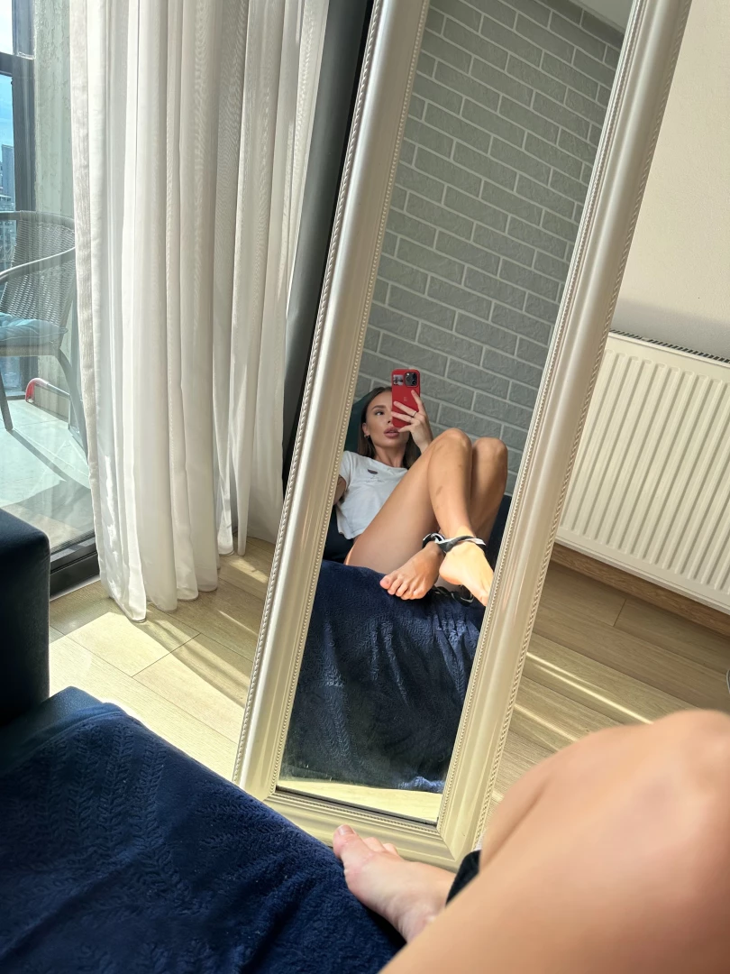 She rests on the bed sunlight caressing her skin her eyes hold a 