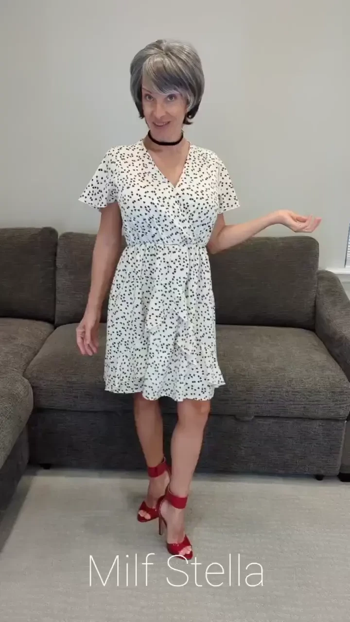 Sadie in a white dress with hearts and red heels 