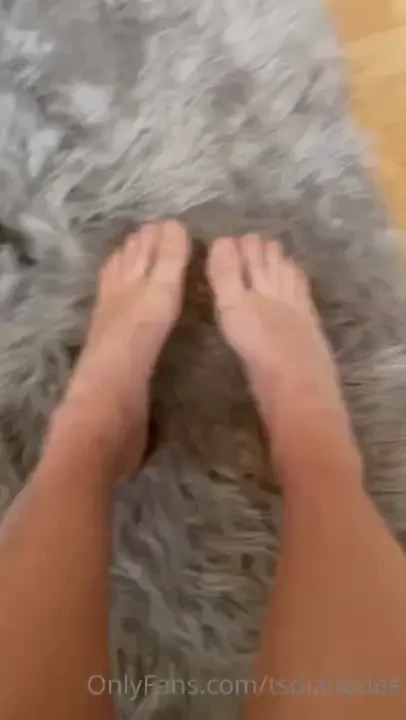 Bare feet on a grey faux fur rug rotating angles and flexes trans lady 