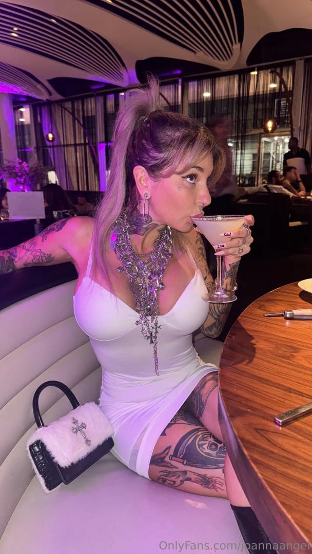 Dressed in white sipping something strong ready to make the night 