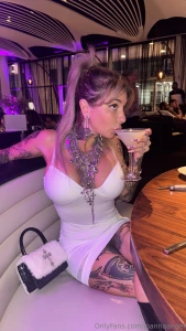 Dressed in white sipping something strong ready to make the night