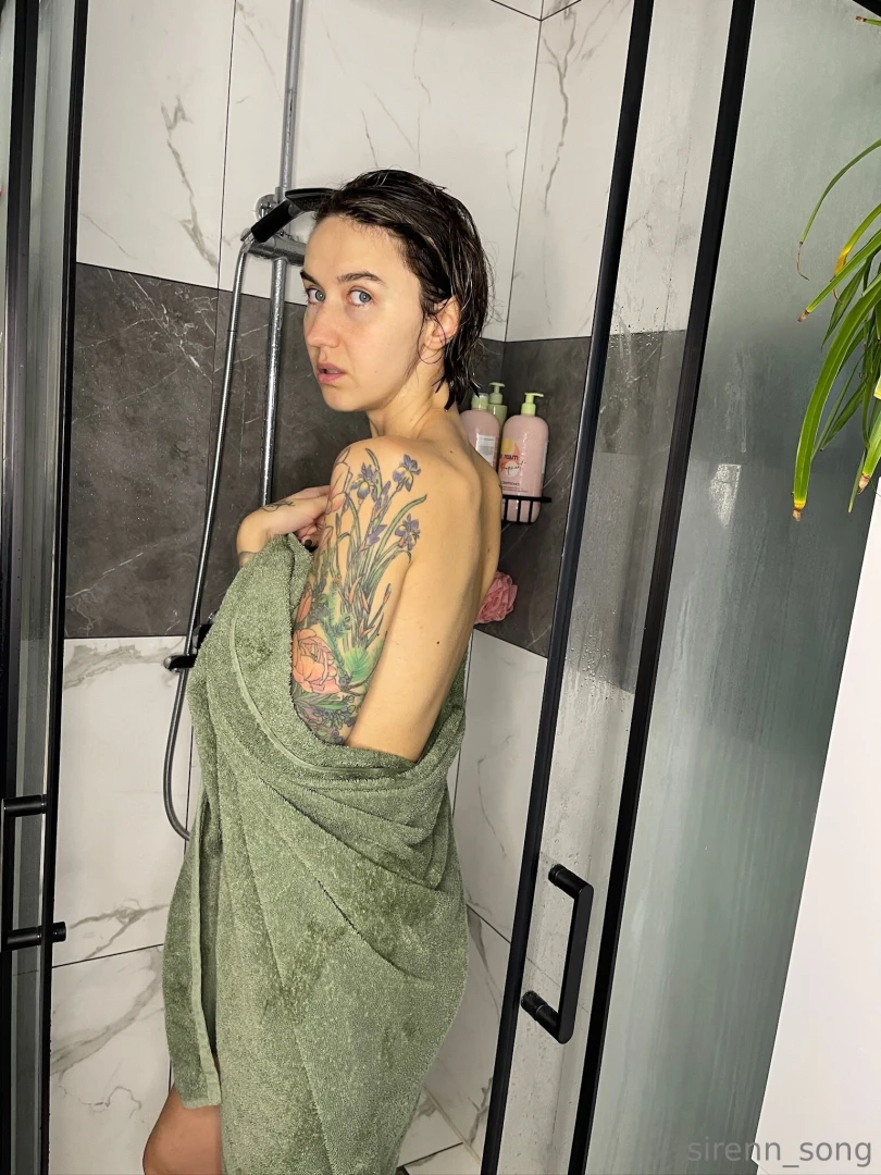 Warmth envelops her body drops of water slowly dripping down her skin 