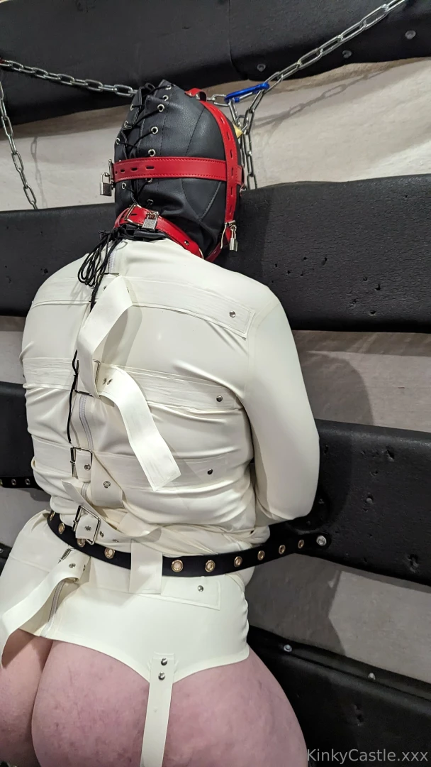 Padlocked hood latex straightjacket and legs held spread using tube 