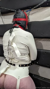 Padlocked hood latex straightjacket and legs held spread using tube