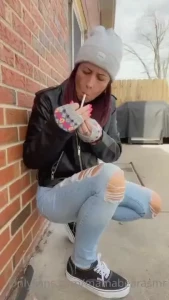 Smoking outside in leather jacket crushing cigarette