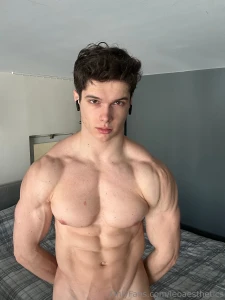 Standing tall in front of the bed biceps flexed abs tight just enough