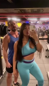 Giving a class at the gym to my student helping her squat while