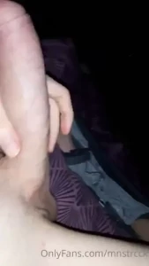A monster cock in bed with a trickle of precum