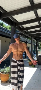 Outside with just a towel around my waist abs cut biceps flexed how