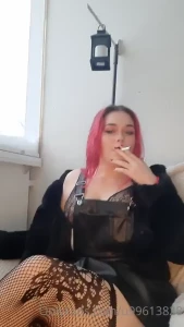 Wearing fishnet stockings a leather dress and a black bra with black