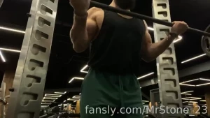 Doing a biceps curls with a straight barbell hairy beard mustache flex