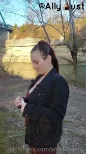 Opening a new pack and smoking by the water in a dress and jean jacket