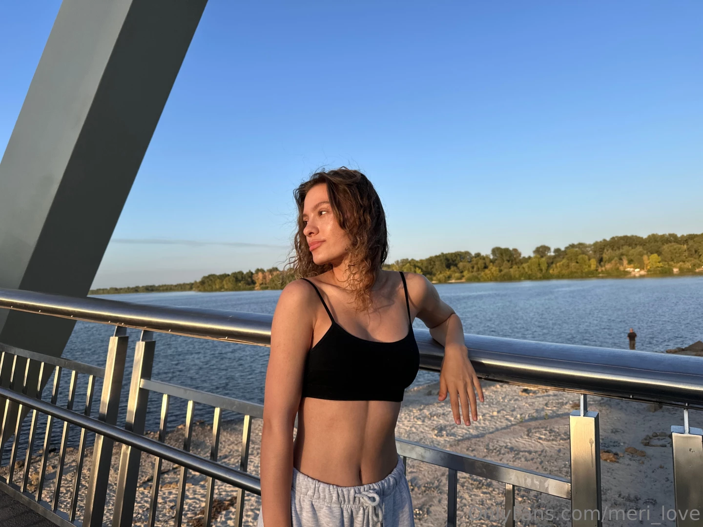 She stands at the edge of the promenade enveloped in a light breeze 