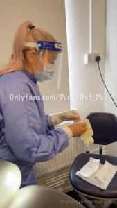 Nurse amy pulls on her surgical gloves wearing full surgical attire