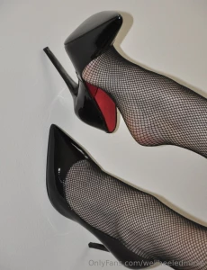 Fishnet stockings love the red inside of these black patent highheels