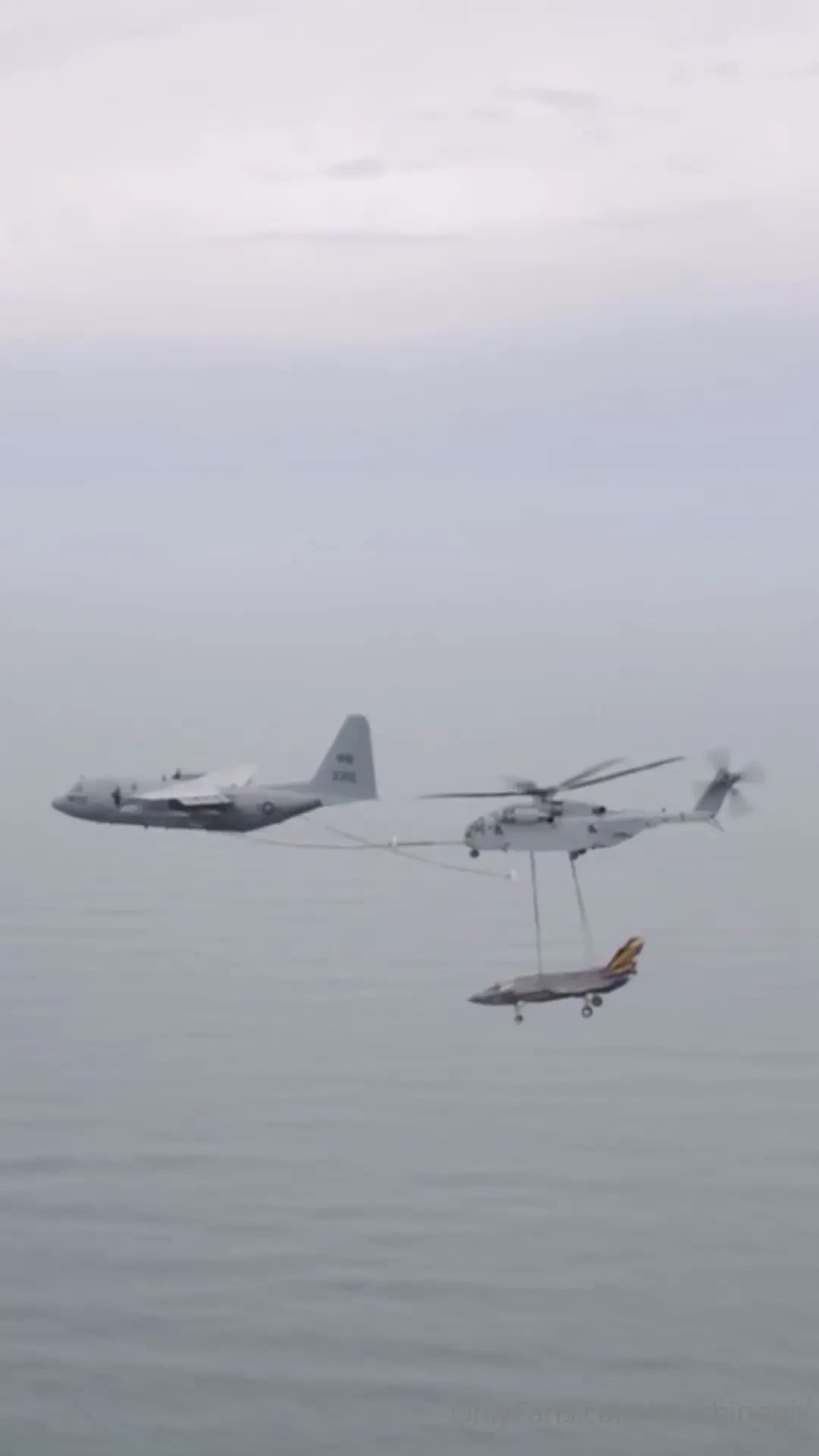 Navy kc-130 fueling a marine corp ch-53 carrying a navy f-35 