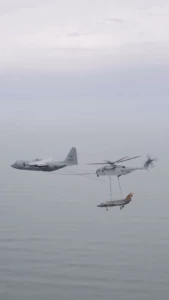 Navy kc-130 fueling a marine corp ch-53 carrying a navy f-35