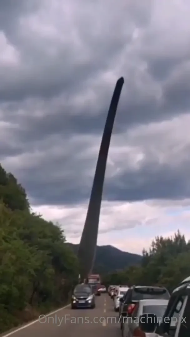Xcmg group truck carrying a wind turbine blade up a mountain 